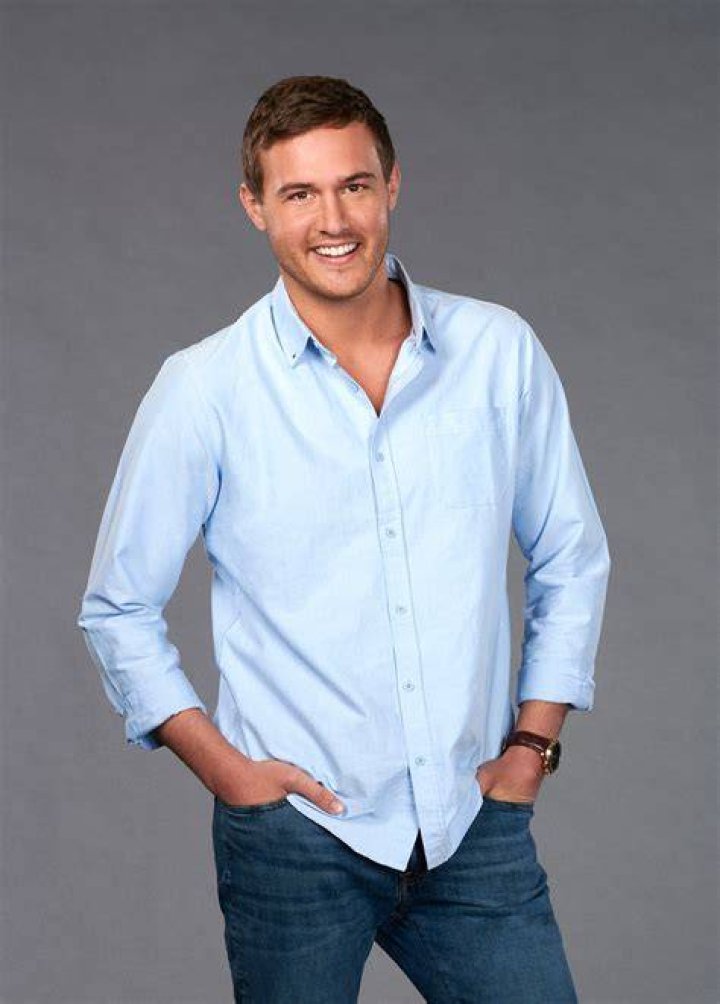 Bachelor Peter Weber Laughs While Holding a Rose in a Pile of Rose Petals